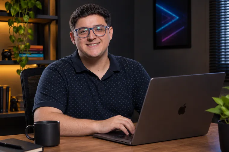 Arthur Monteiro, desenvolvedor web, trabalhando no notebook em seu escritório